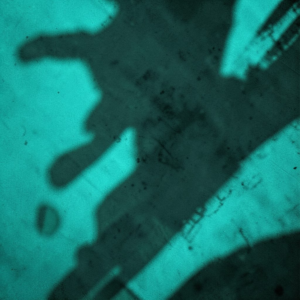 Studio mirror reflecting a dancer's silhouette, dim atmospheric lighting, cool blue duotone